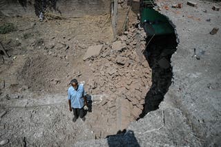Bairi Ram, a local resident, stands next to his house damaged by overnight Pakistani artillery shelling in Kotmaira village near the Line of Control (LoC) in India's Jammu region on May 11, 2025.